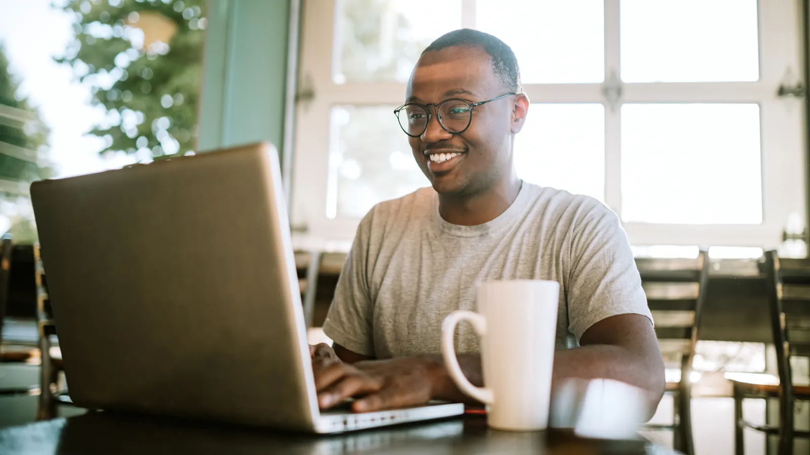 Smiling person using a laptop to represent audience intelligence and enrichment